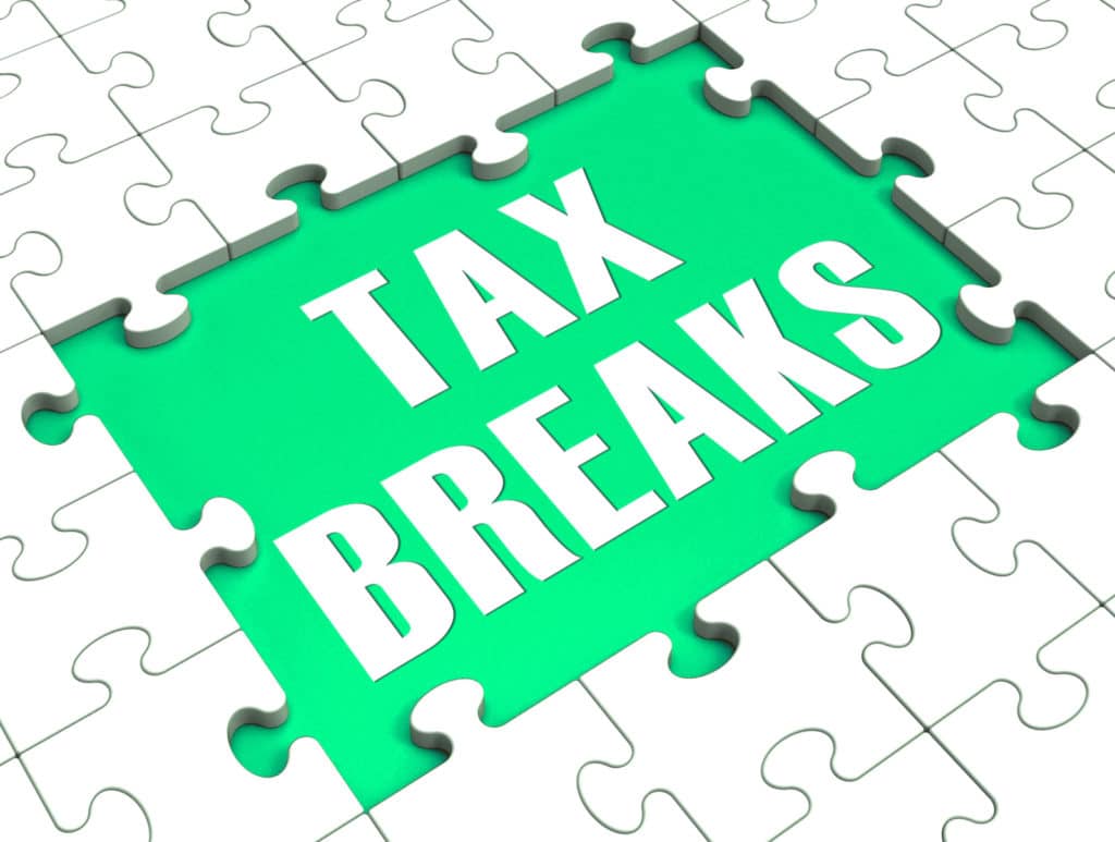 A puzzle with missing pieces revealing ‘tax breaks’ text.