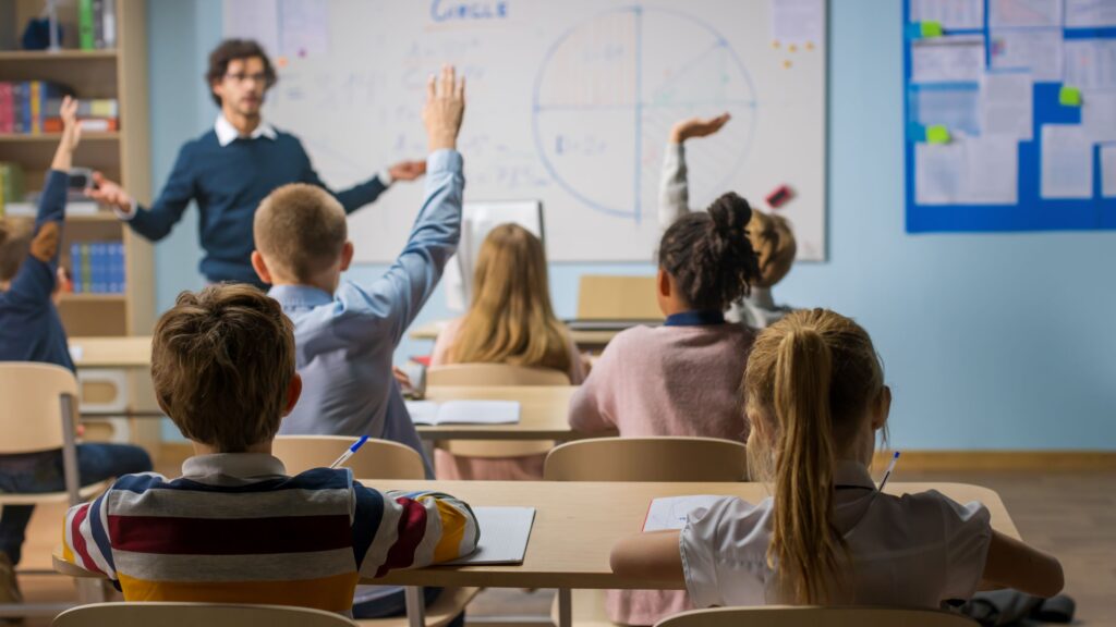 A middle school teacher explains a math lesson to students.