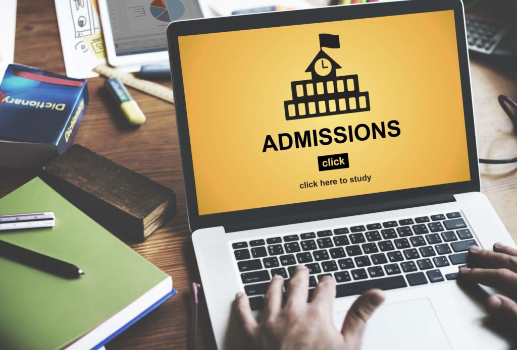 A student looks at a university admissions page on their laptop.