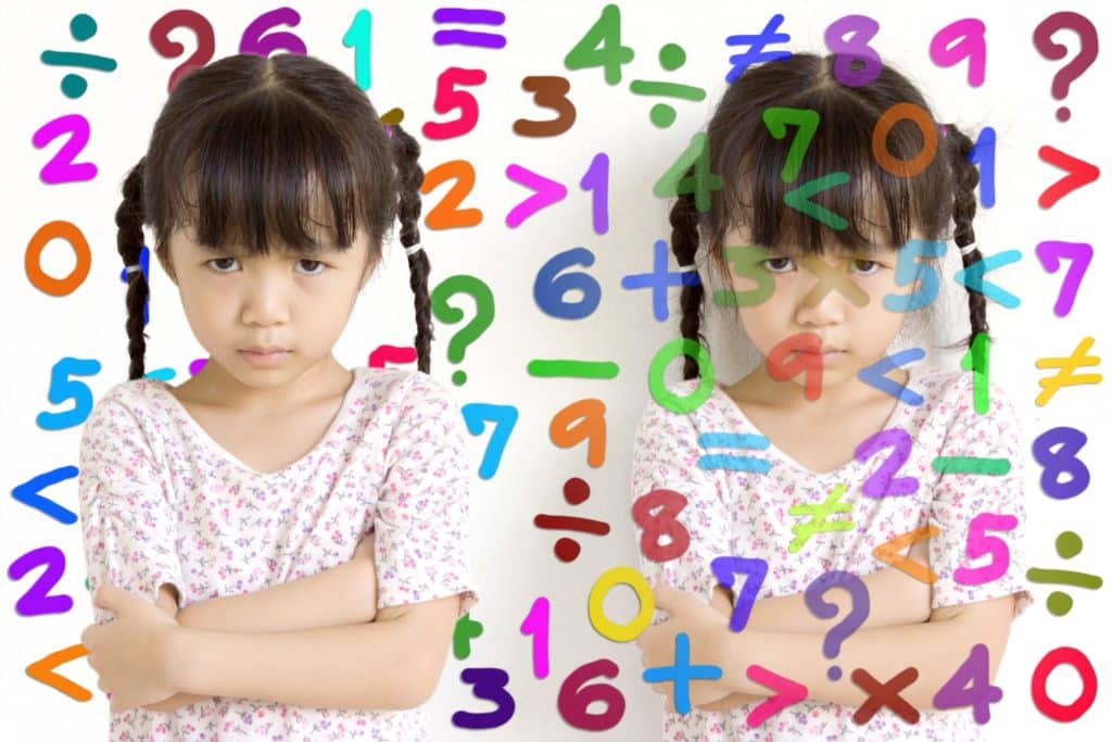 A little girl looks stressed while studying mathematics.