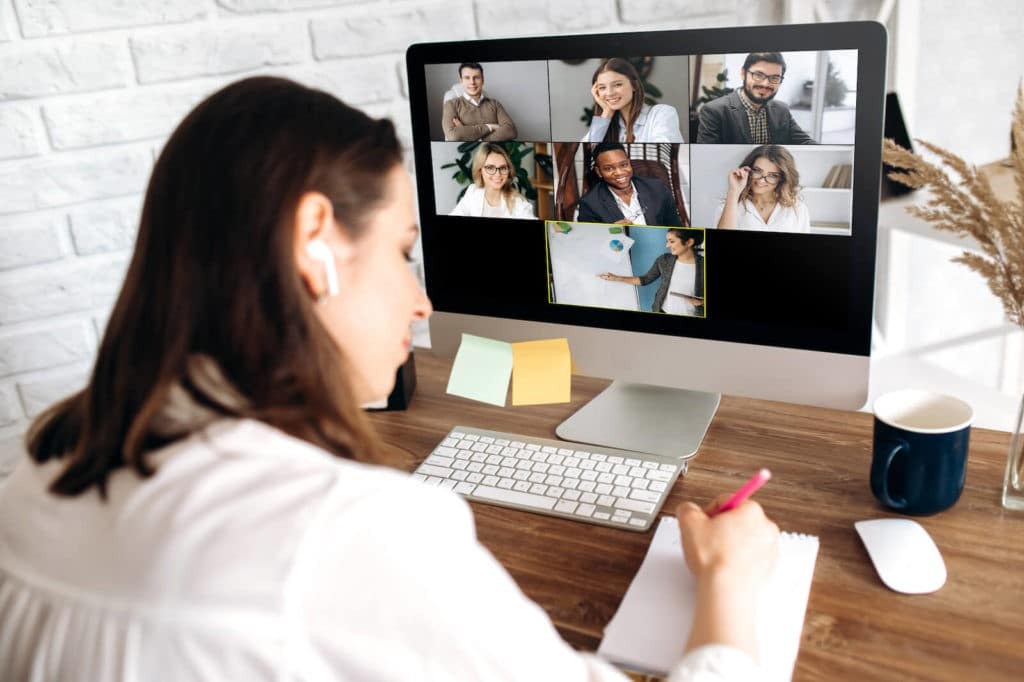 Group of teachers on a video call talking to each other and taking notes.