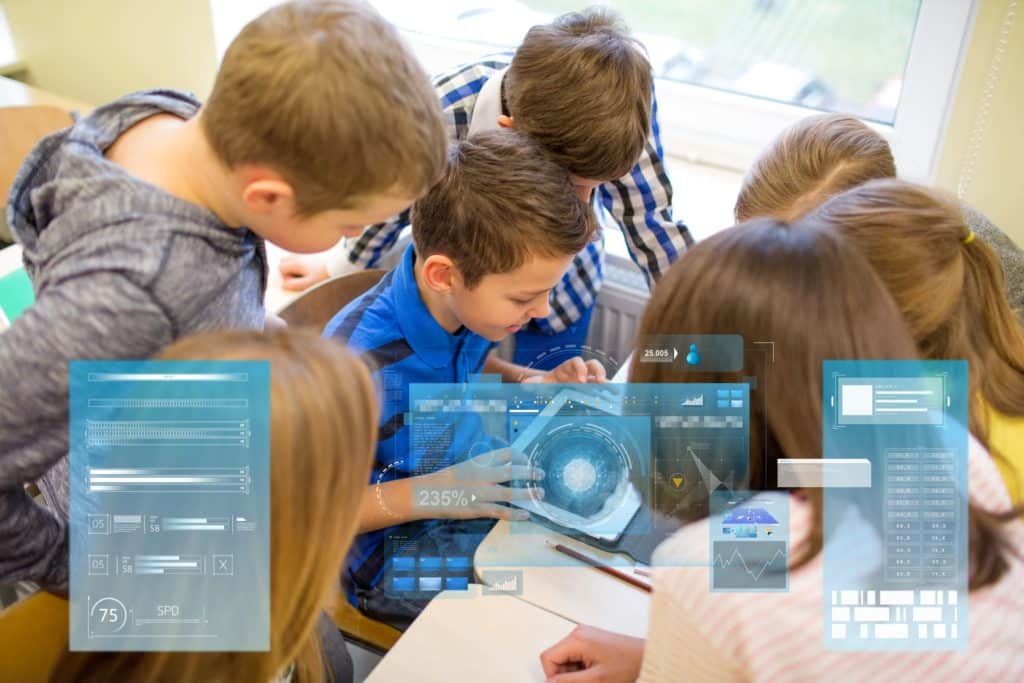 A group of elementary students work on an educational game on a tablet in the classroom.