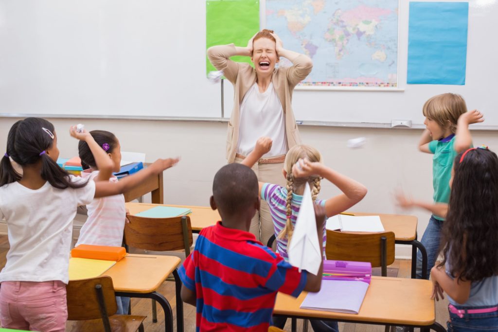 Difficult students misbehave in class, throwing paper at their teacher.